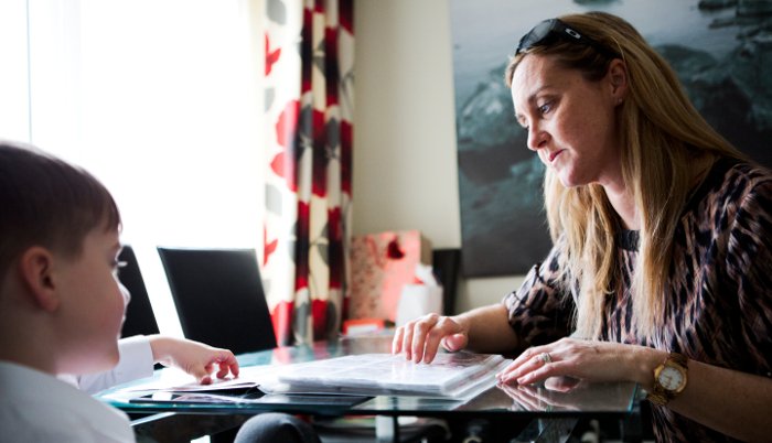 A woman and a child reading braille.