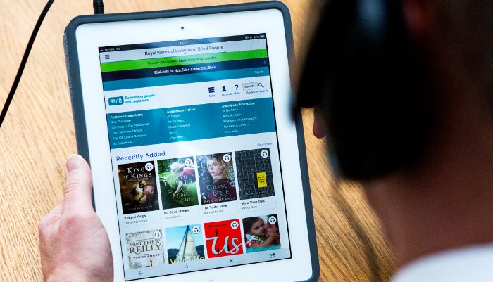 A person uses RNIB library services on a tablet.
